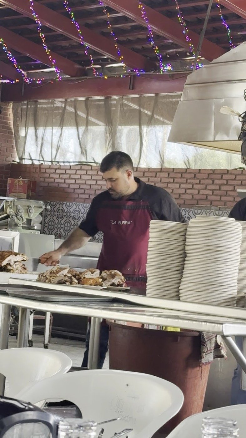 Parrillero sirviendo carne en la barra